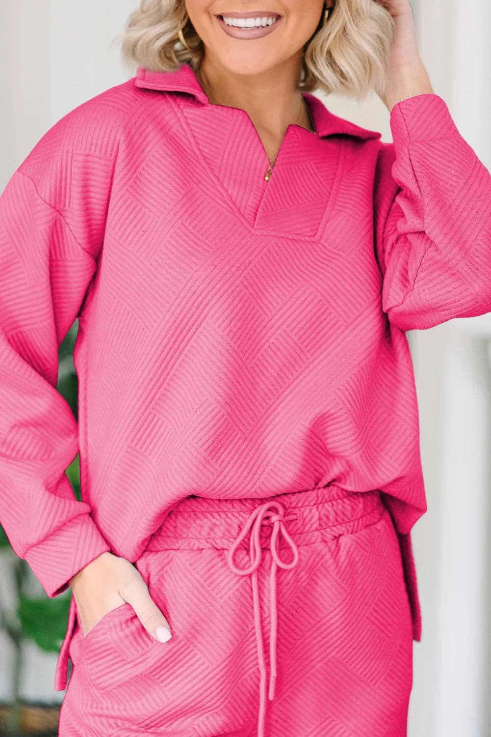Person wearing a pink textured outfit with a white background
