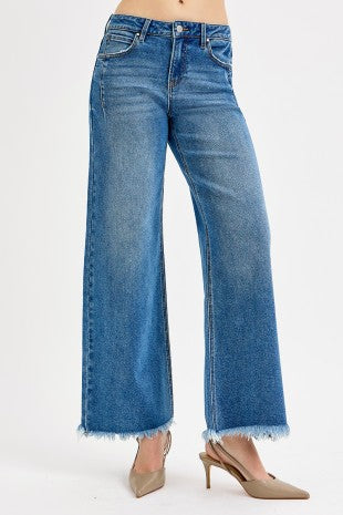 Blue jeans with a frayed hem on a white background