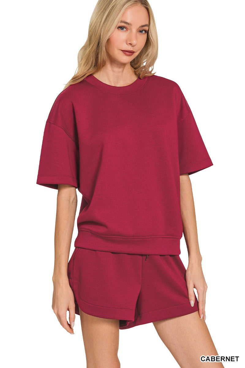 Woman wearing a maroon outfit with a plain background