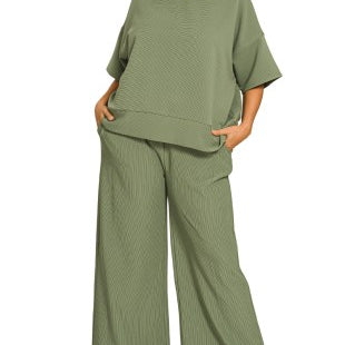 Woman wearing a light olive green outfit on a white background