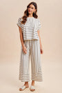 Woman wearing a striped outfit on a beige background