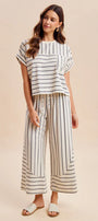 Woman wearing a striped outfit on a beige background
