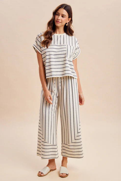 Woman wearing a striped outfit on a beige background