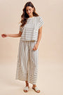 Woman wearing a striped outfit on a beige background