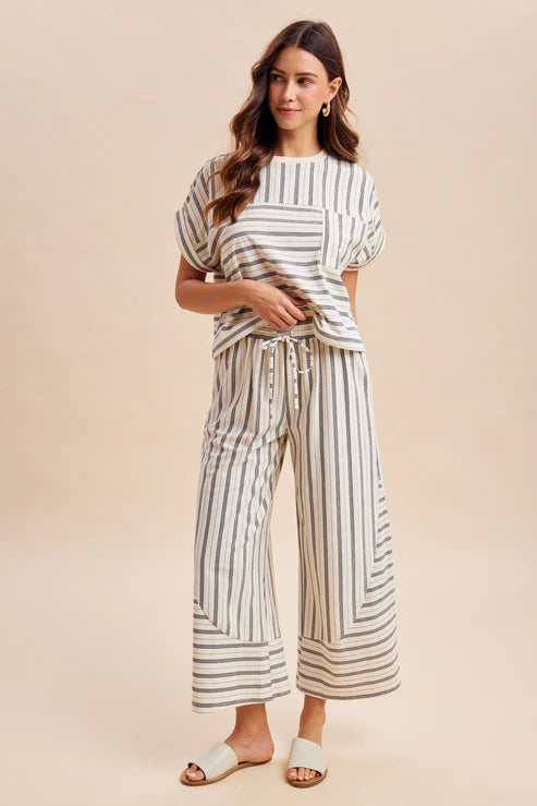 Woman wearing a striped outfit on a beige background