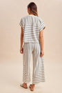 Woman wearing a striped outfit with a beige background