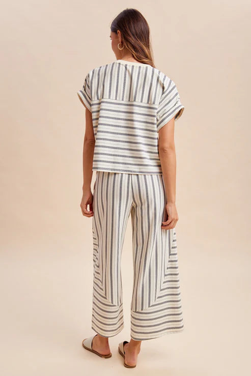 Woman wearing a striped outfit with a beige background