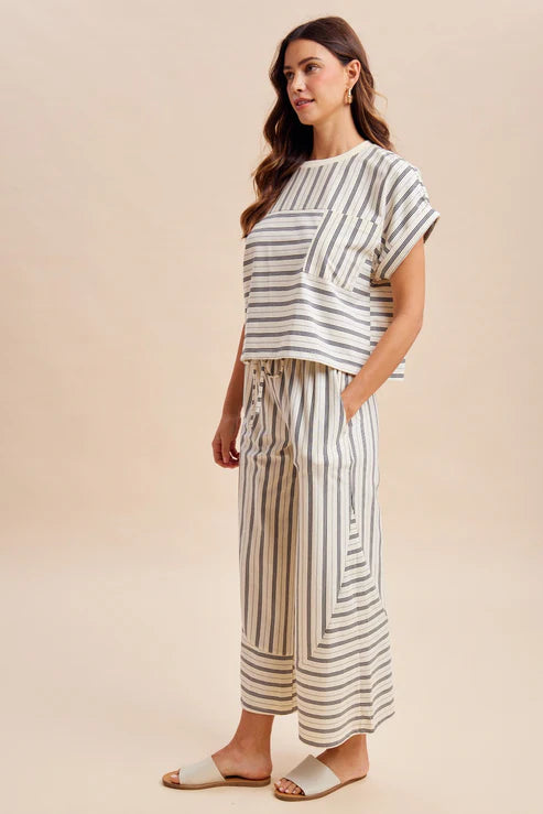 Woman wearing a striped outfit on a beige background