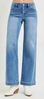 Blue jeans worn by a person on a light gray background