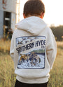Child wearing a hoodie with 'Southern Hyde Co.' design in a field