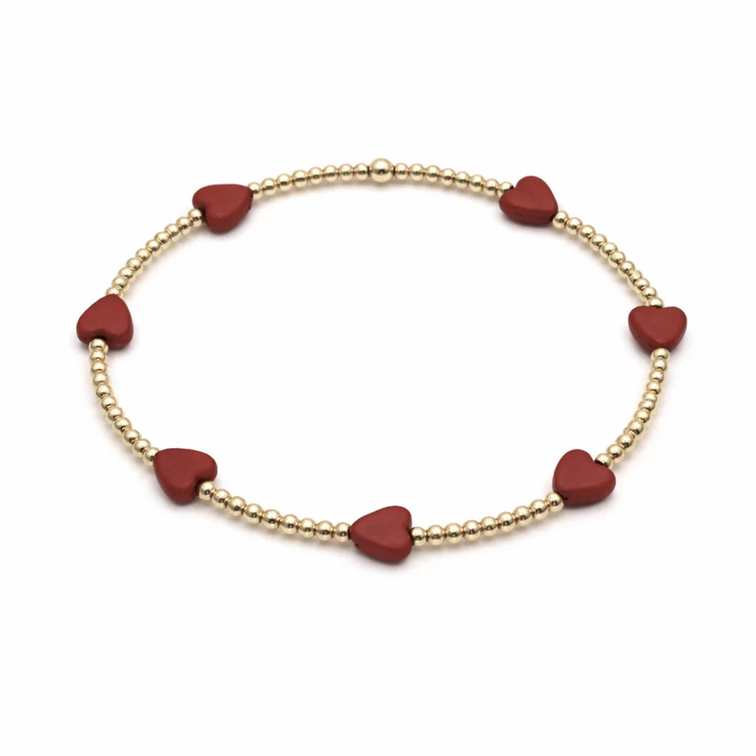 Bracelet with red heart-shaped beads on a gold chain against a white background