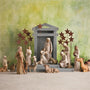Nativity scene with figures and stable against a green background