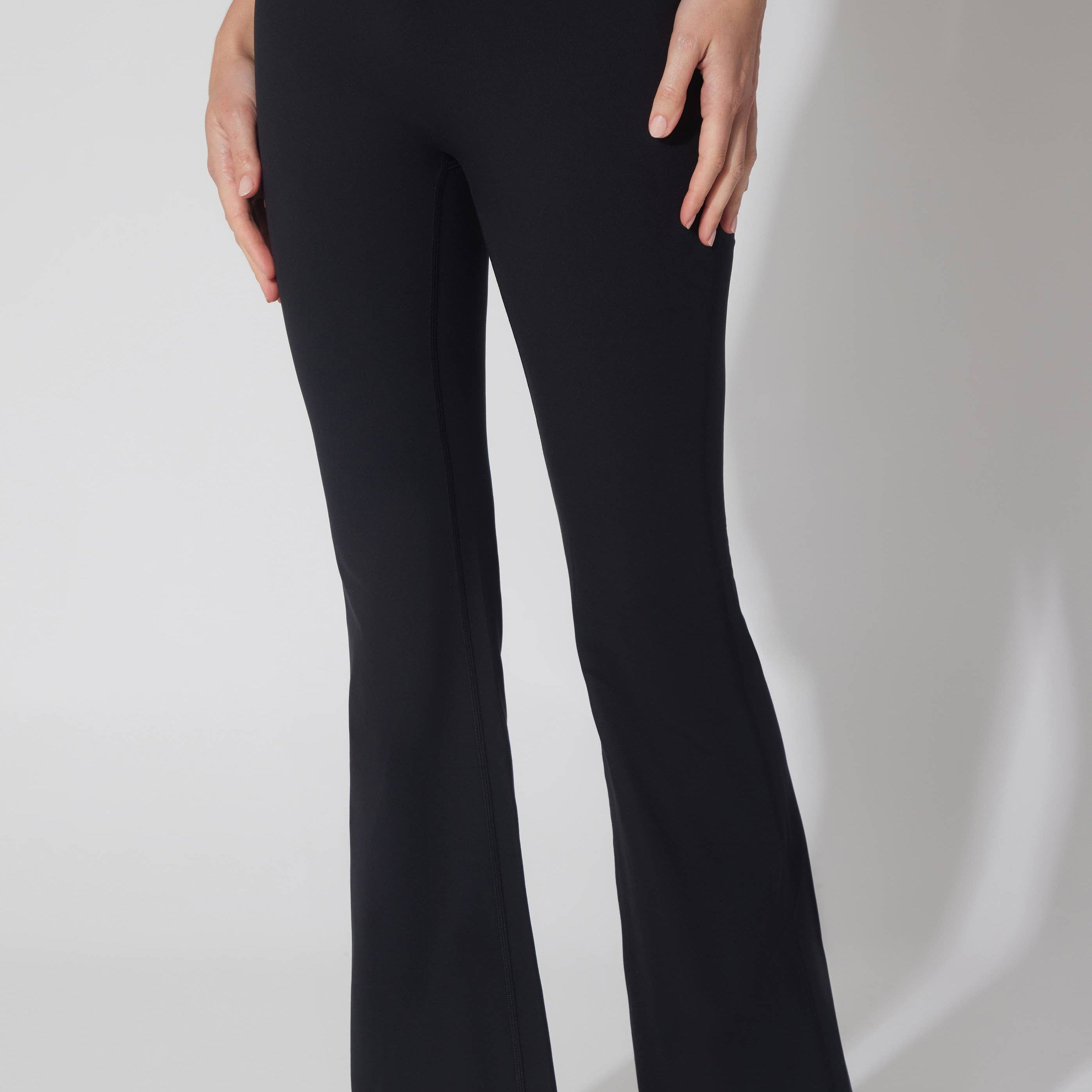 Black pants worn by a person on a white background