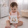 Baby holding soft farm animals cloth crinkle book with cow page and fabric handle