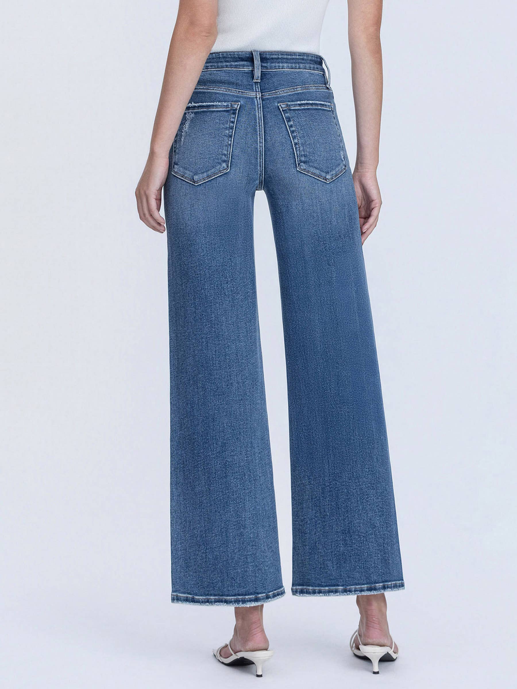 Person wearing blue wide-leg jeans on a white background