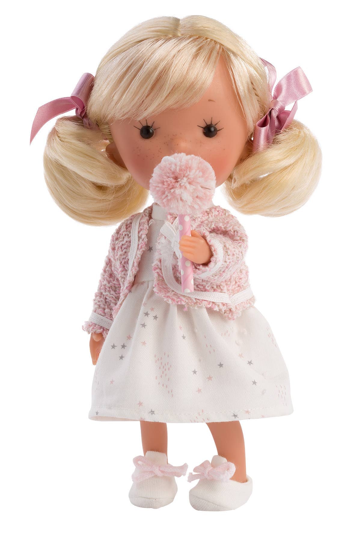 Doll with blonde hair, pink ribbons, and a white dress holding a pink flower on a white background