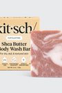 Shea butter body wash bar with packaging on a light gray background