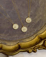 Three gold necklaces with round pendants on a decorative gold frame.