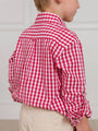 Child wearing a red and white checkered shirt against a plain background