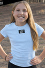 Young girl wearing a Light blue t-shirt with 'LULU MAC' logo outdoors.