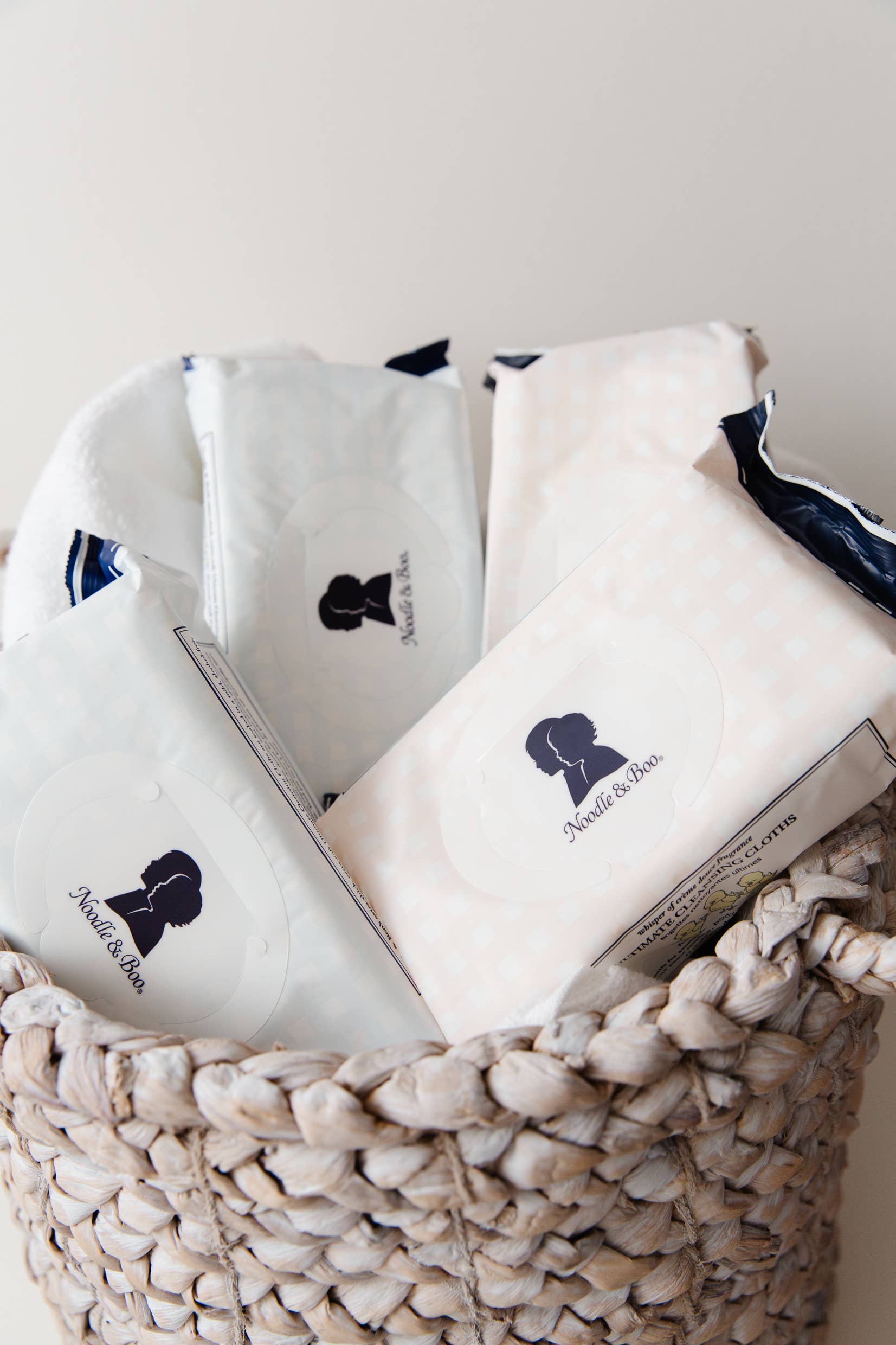 White pillows with a logo in a woven basket on a light background