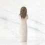 Decorative figurine of a woman with braided hair on a marble background