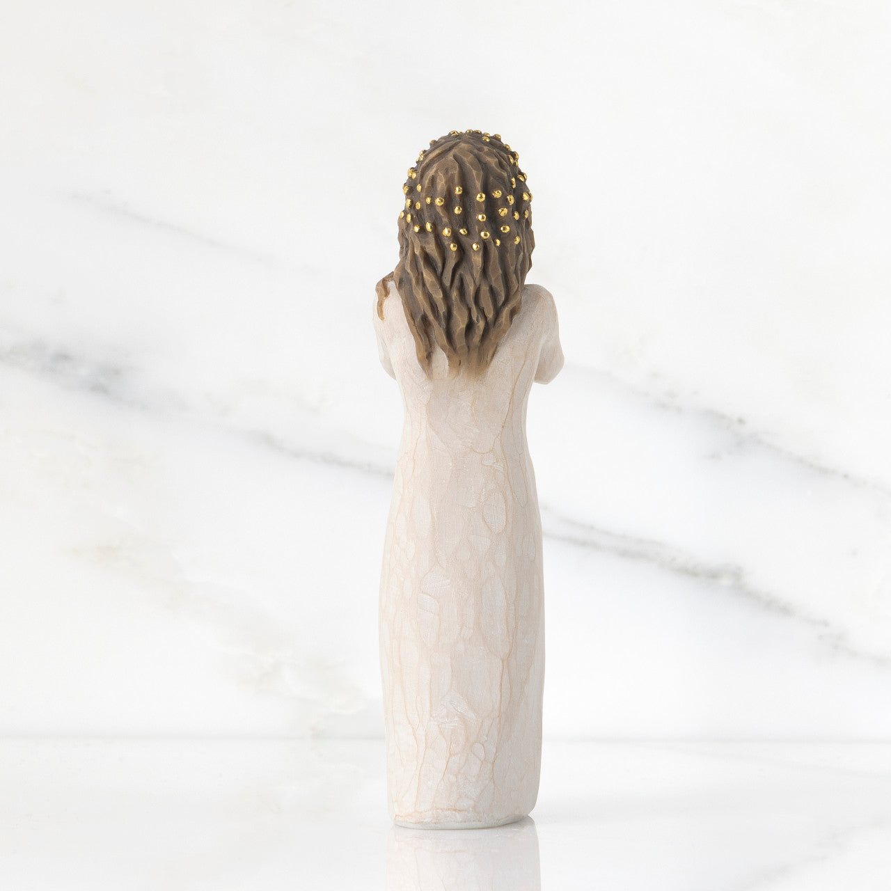 Decorative figurine of a woman with braided hair on a marble background