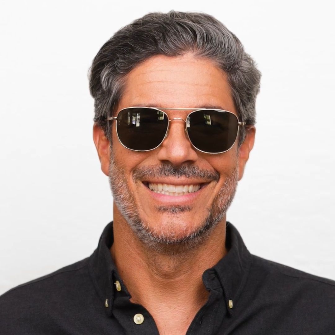 Man wearing sunglasses with a neutral background