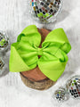 Large green bow on a wooden block with disco balls in the background