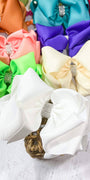 Colorful hair bows with rhinestones on a light wooden surface