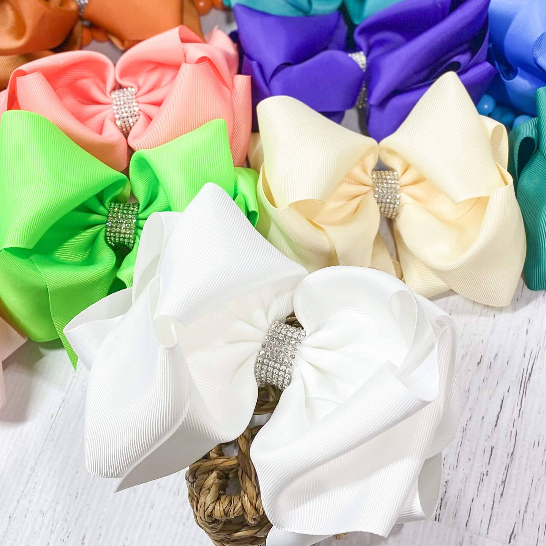 Colorful hair bows with rhinestones on a light wooden surface