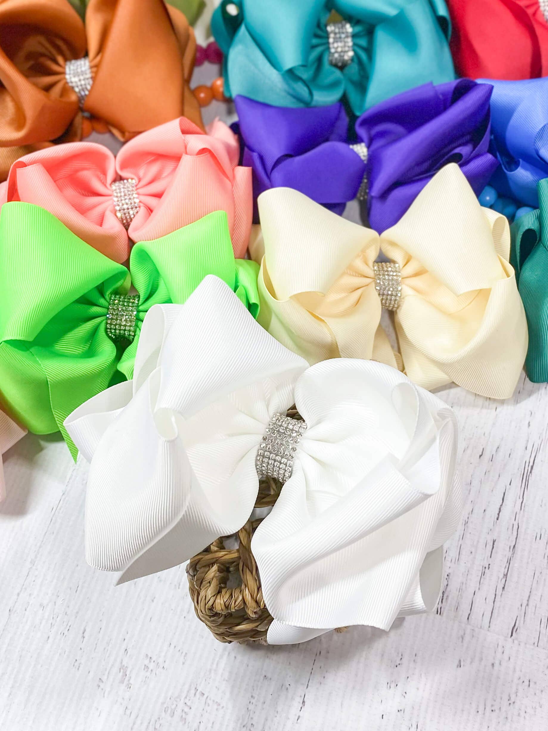 Colorful hair bows with rhinestones on a light wooden surface
