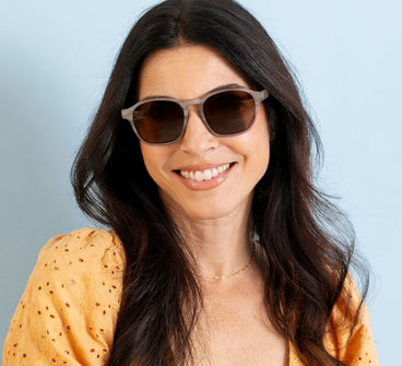 Woman wearing sunglasses with a plain background