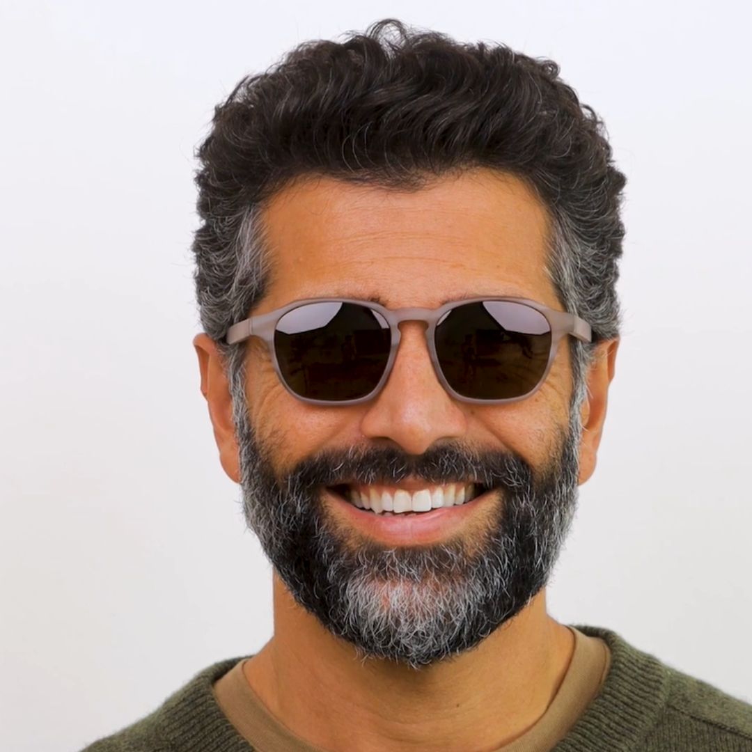 Man wearing sunglasses with a neutral background