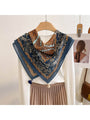 Navy retro floral square scarf with tassels and patterned border, draped on hanger