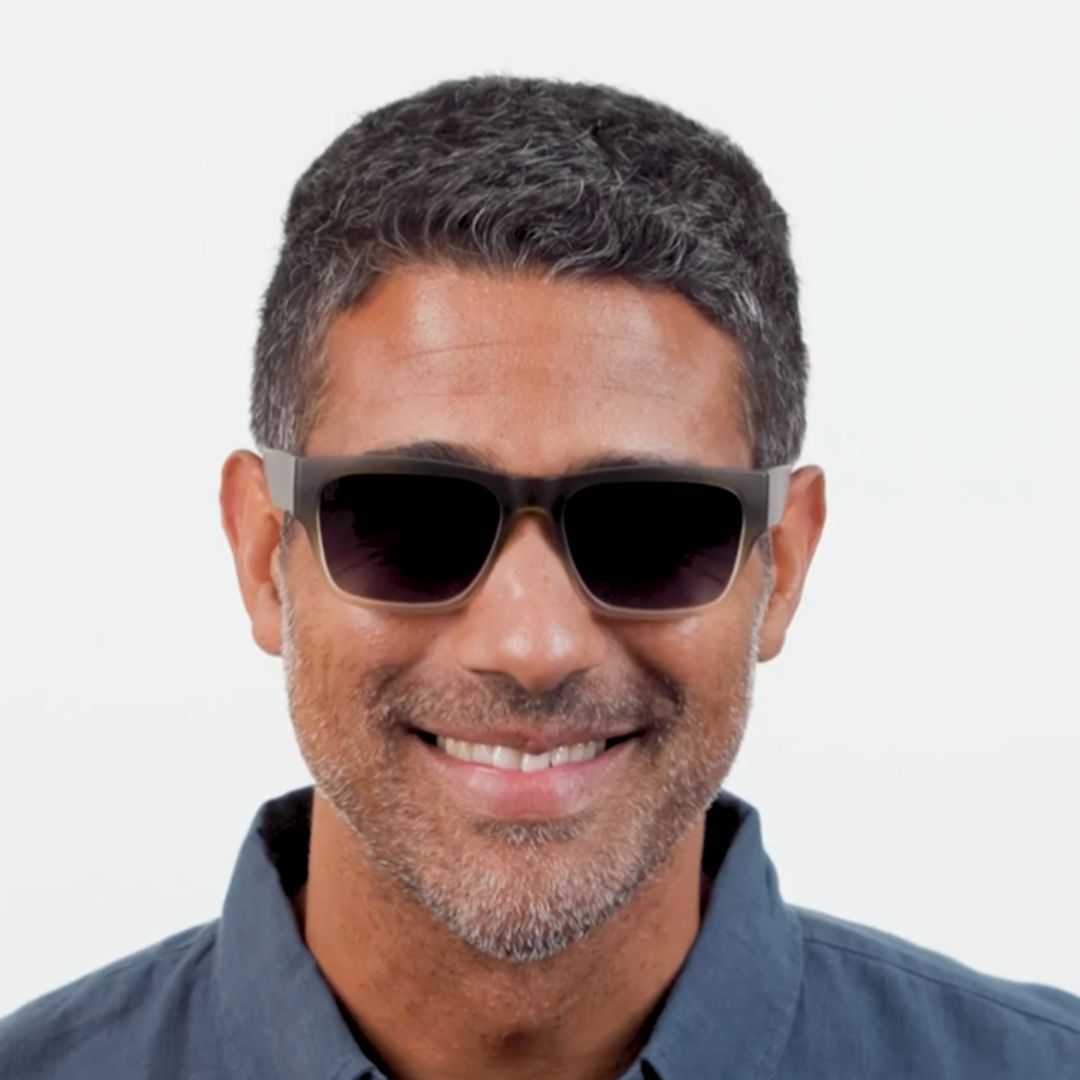 Man wearing dark sunglasses with a light gray background