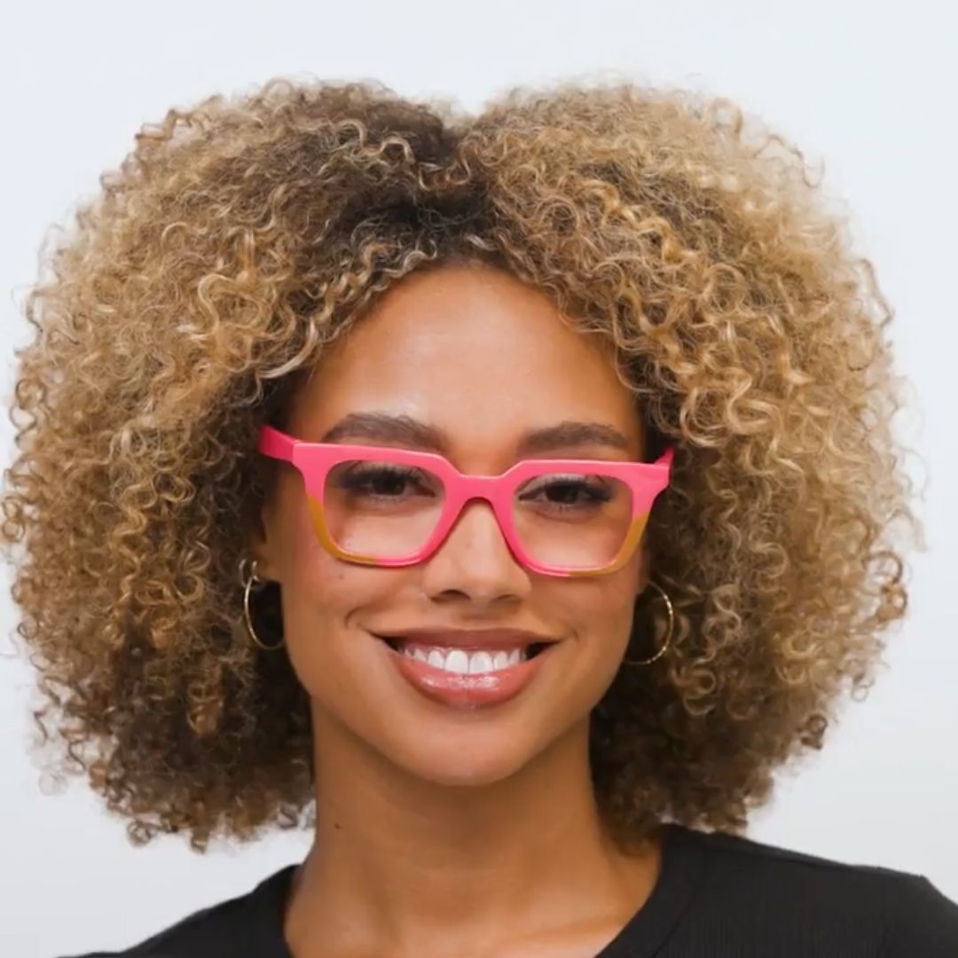 Woman wearing pink glasses with a plain background