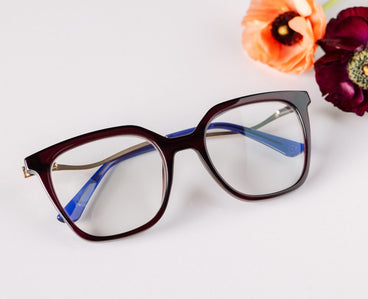 Cat-eye glasses with blue arms on a white background with flowers.