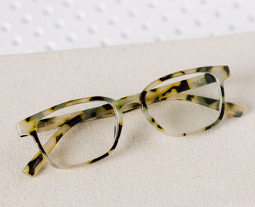 Eyeglasses with a yellow tortoiseshell frame on a white background