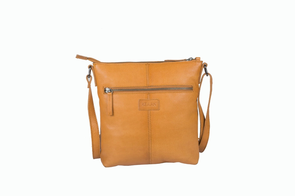 Tan leather crossbody bag on a white background
