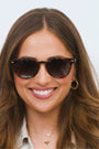 Woman wearing sunglasses with a plain background