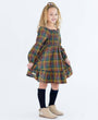 Young girl wearing a plaid dress on a white background