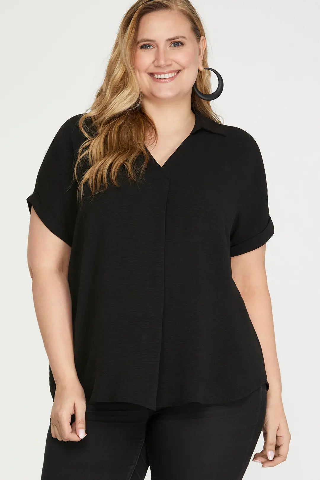 Woman wearing a black short-sleeve blouse against a white background