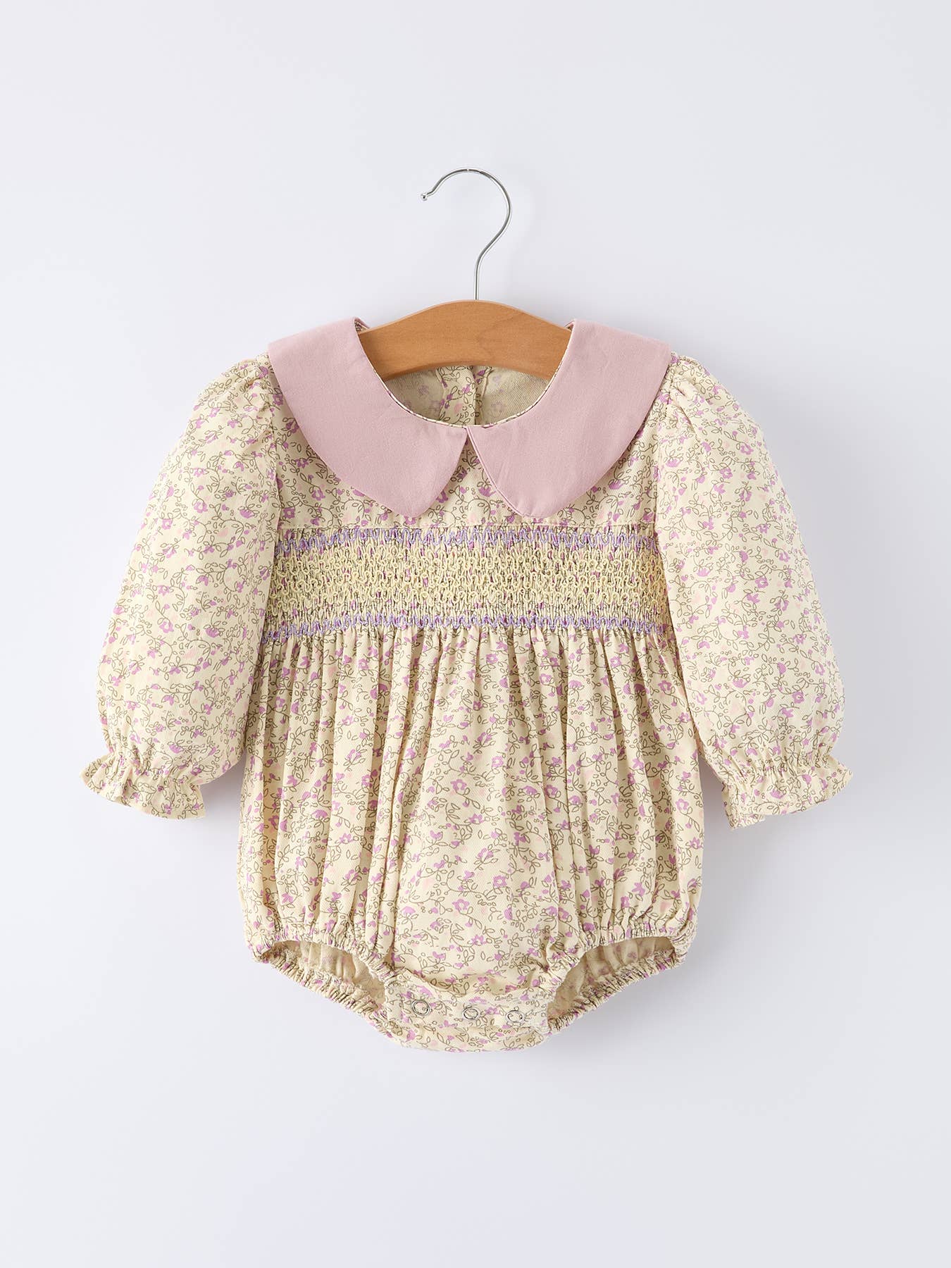 Baby romper with floral pattern and pink collar on a white background
