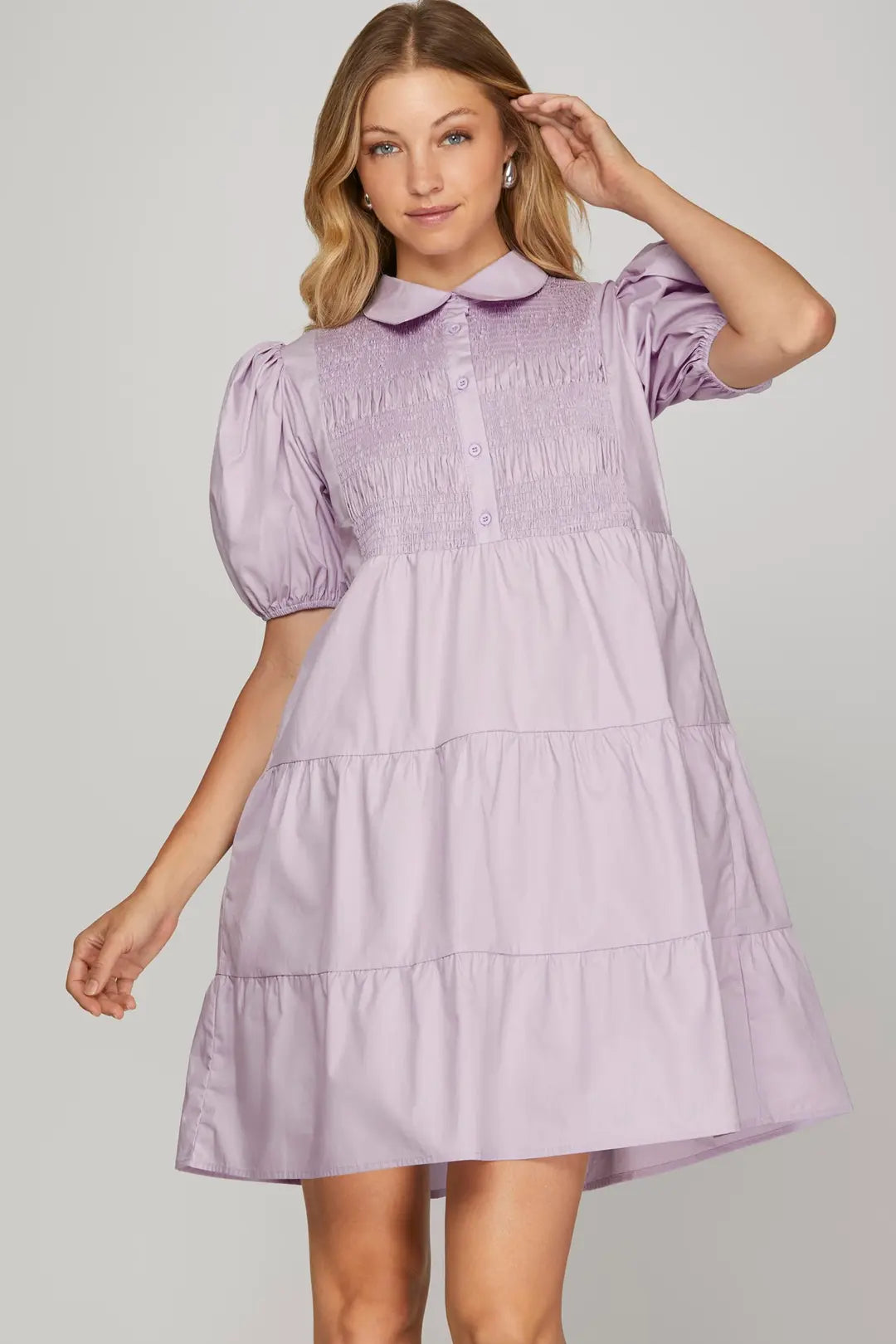 Woman wearing a lilac dress with a plain background