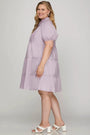 Woman wearing a light purple dress with a plain background