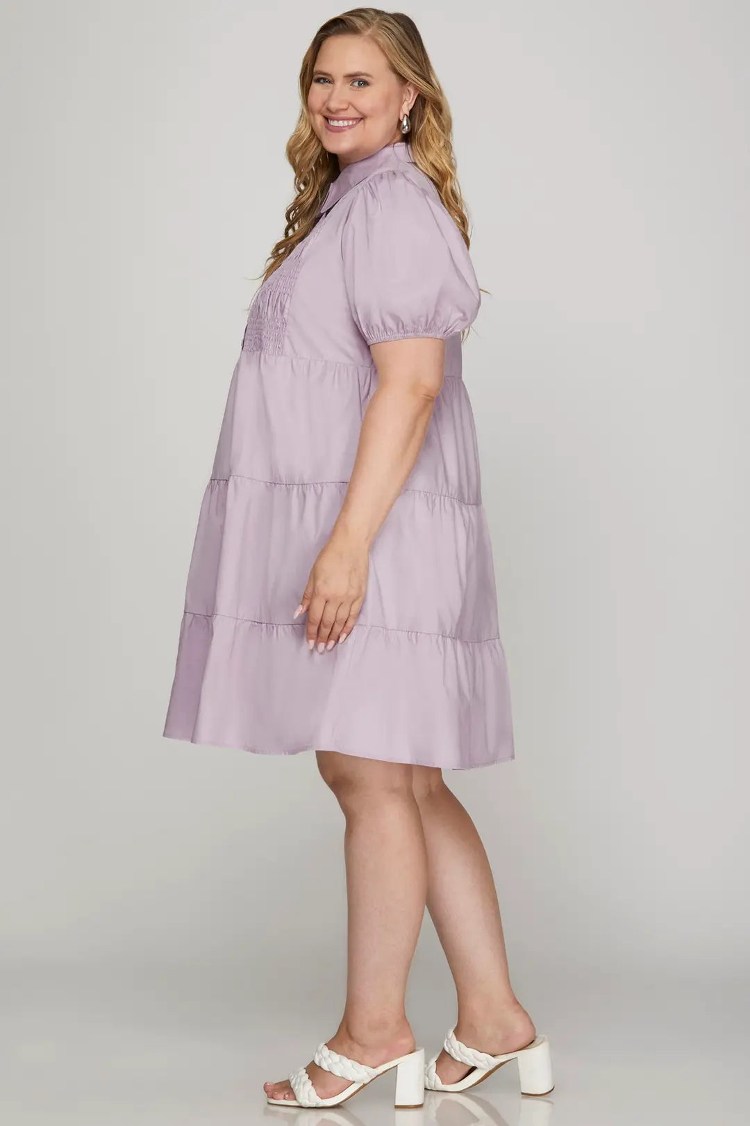 Woman wearing a light purple dress with a plain background