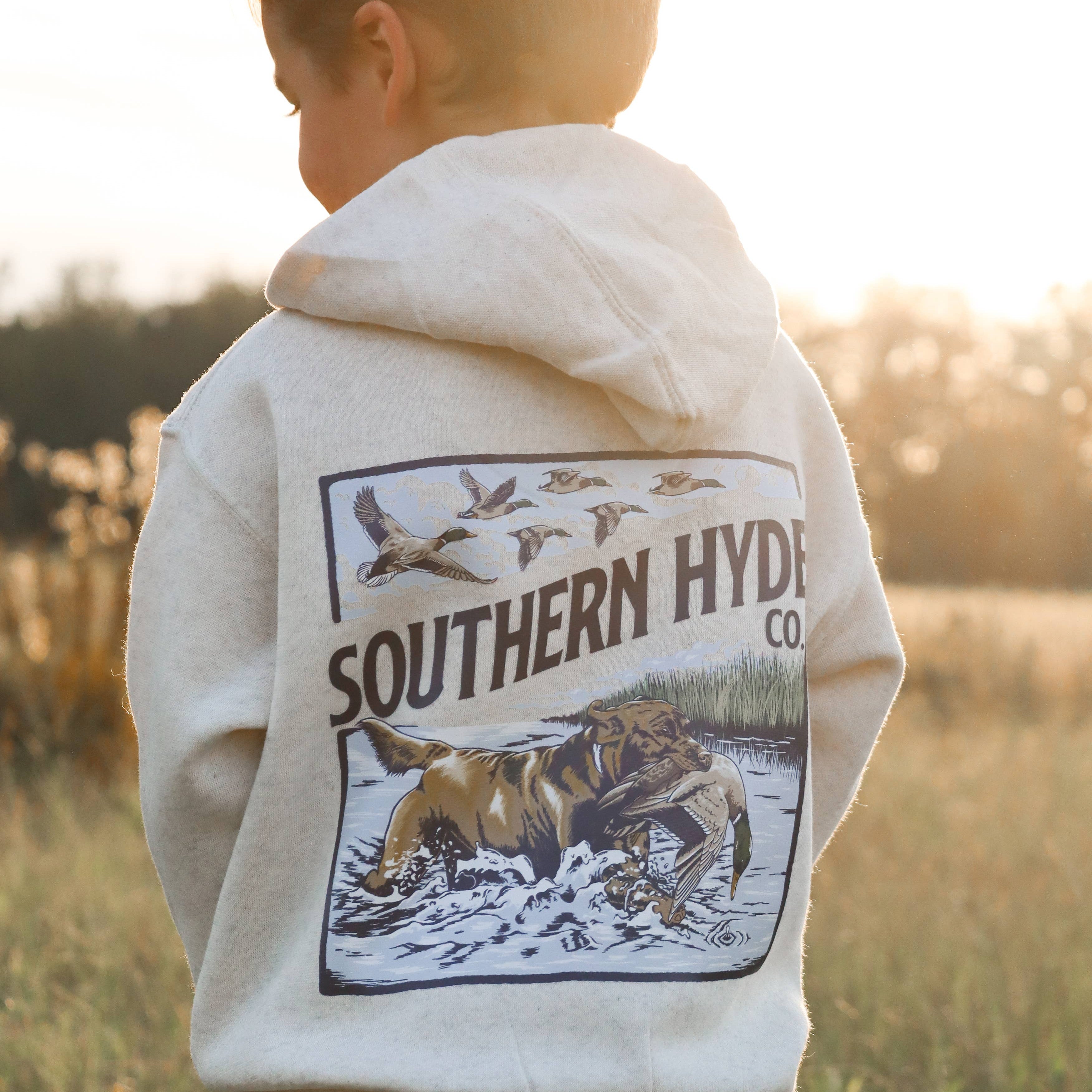 Child wearing a hoodie with 'Southern Hyde' logo in a field