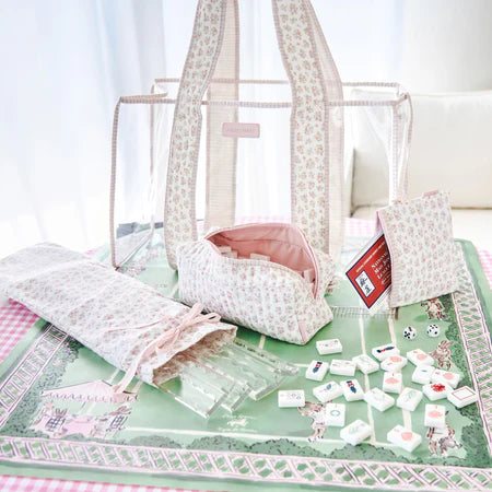 Set of white and pink bags with decorative elements on a green surface