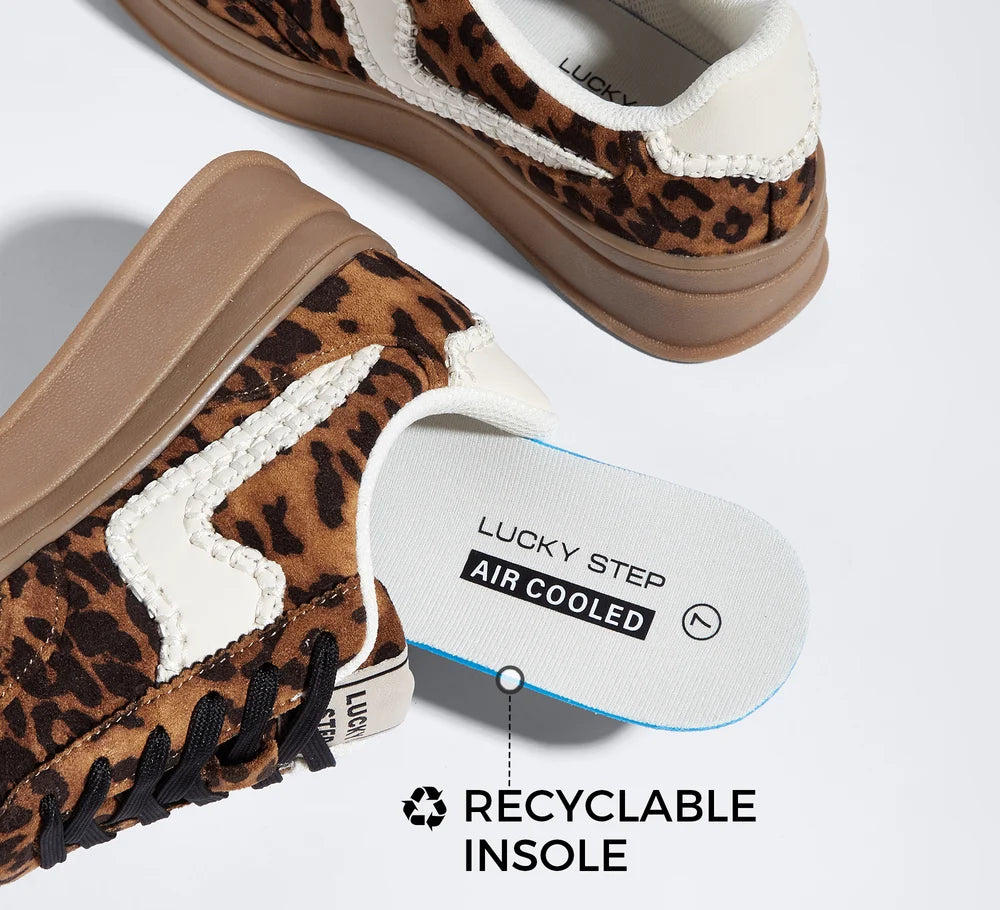 A pair of low-top sneakers with a brown and black leopard print pattern, white contrast stitching, and a gum brown sole. One shoe is shown from the side, and the other is angled from above, displaying a white 'LUCKY STEP AIR COOLED' recyclable insole.